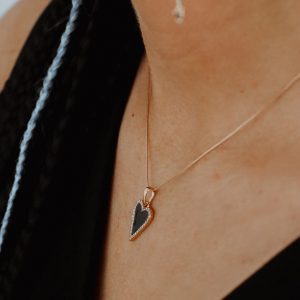 apzeltīta ķēdīte ar melnu sirsniņu